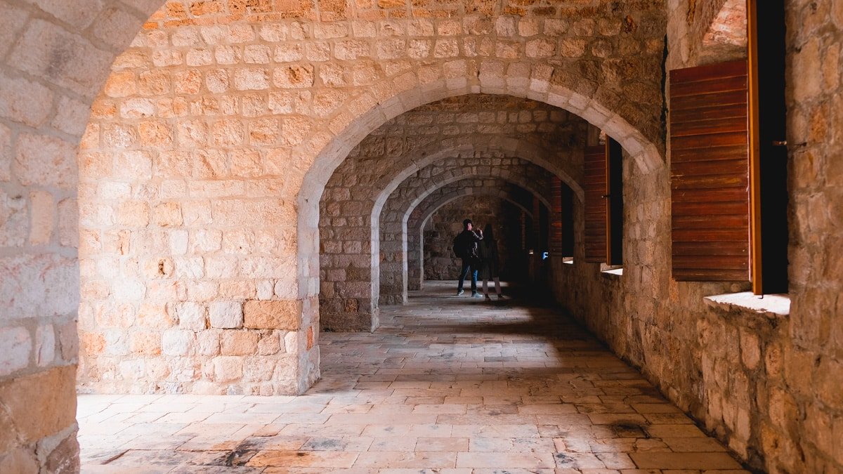 A stone building in Dubrovnik, featuring a hallway with arches perfect for a leisurely walk.