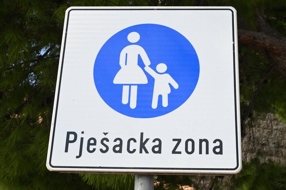 What Language Is Spoken In Croatia - A blue and white sign with a child on it, featuring spoken language in Croatia.
