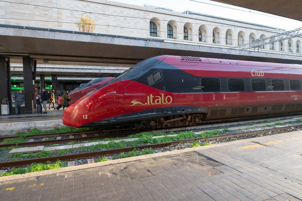 A red and black train traveling through Italy. Rome, Italy: November 13, 2023: Italo high-speed train at the Rome Termini station in Rome in 2023 in Italy.