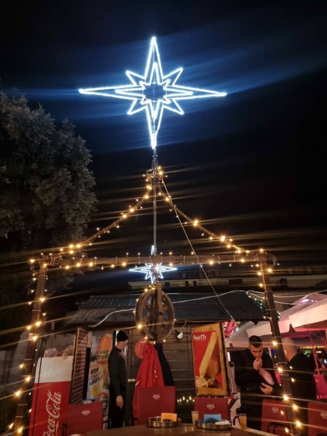 A festive Christmas market in Zadar, adorned with twinkling lights and a majestic star centerpiece.