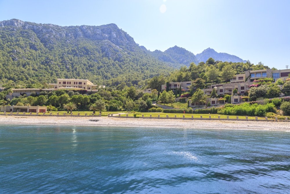A picturesque mountain rising majestically in the background, contrasting beautifully with the stunning Kumlubuk (sandy bay) beach near Turunc in Marmaris