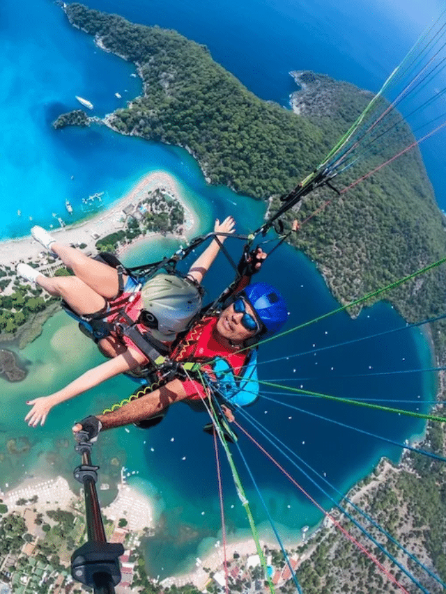 Two people weighing up paragliding over a blue sea in Bodrum.