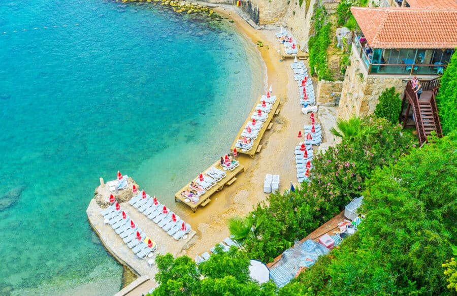 Aerial view of Mermerli beach with the sun beds, stairs to the luxury restaurant, lush garden on the slope and crystal clear water, on May 6 in Antalya.