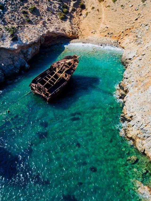A boat nears the rocky shores of Amorgos Island, a hidden gem in Greece known for its pristine beaches.