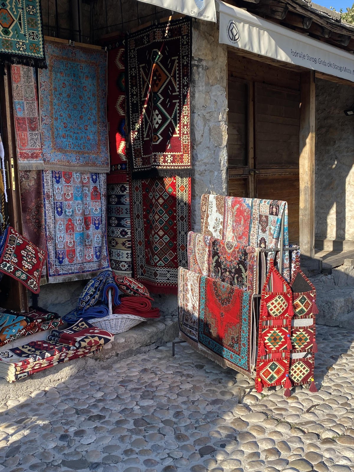 A building with a lot of rugs in front of it, perfect for day trips from Dubrovnik to Mostar.