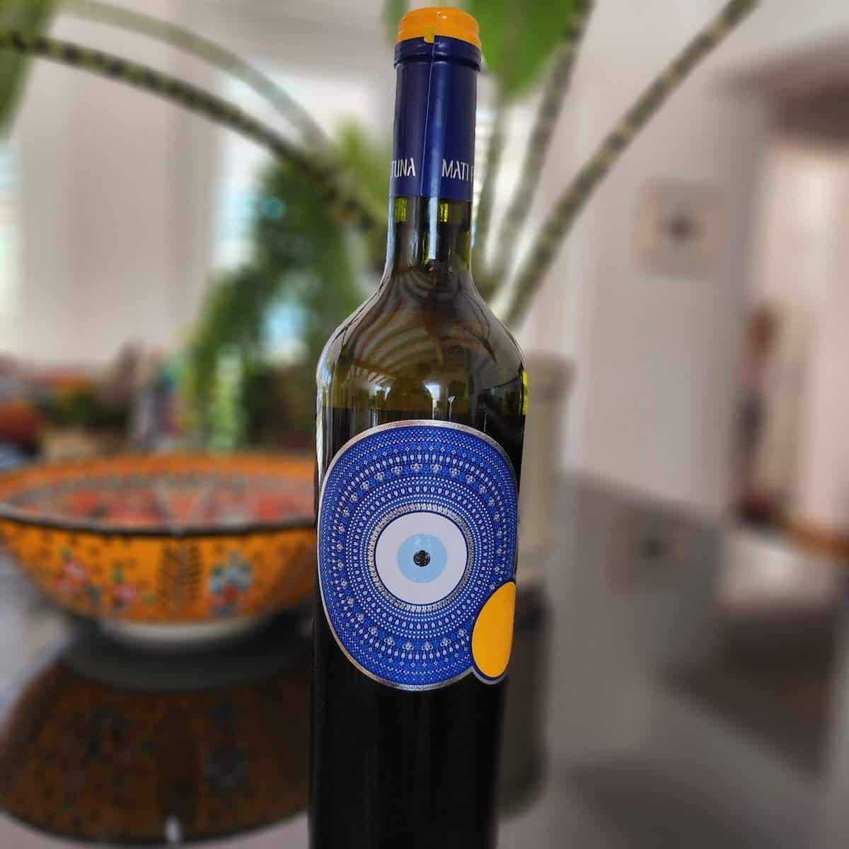 A bottle of wine with an evil eye embellishment from Greece.