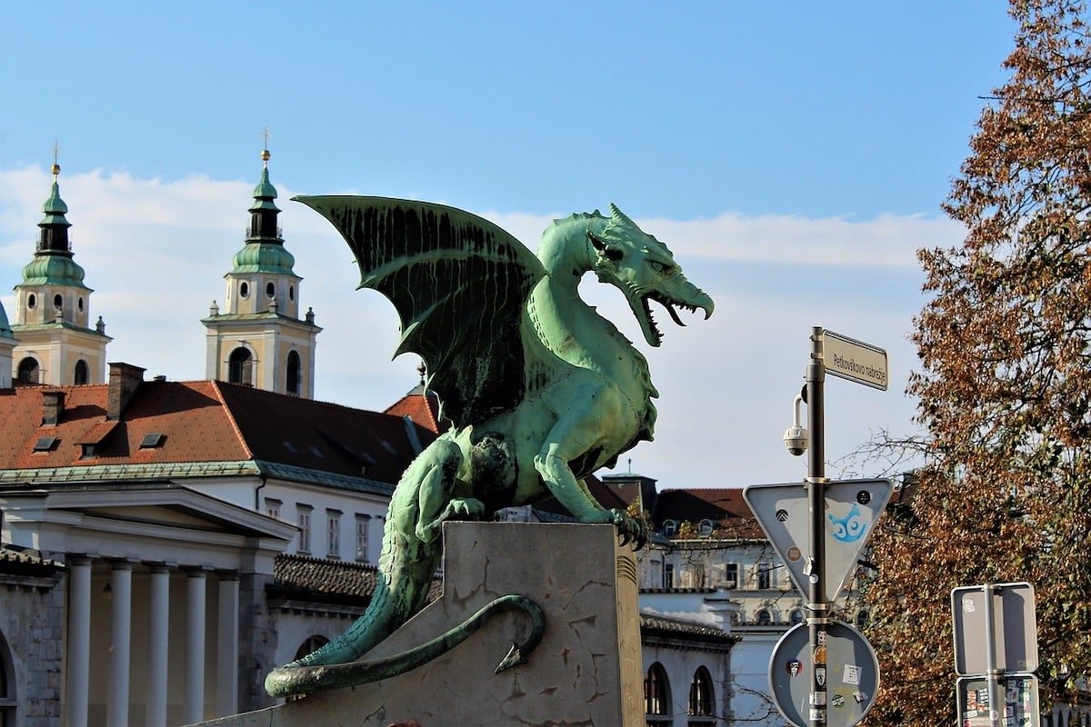 One of the many things to do in Ljubljana is to visit a majestic green statue of a dragon that stands proudly in front of a building.