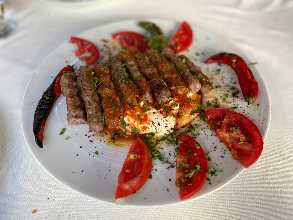 Turkish manisa kebap served on pita bread with tomatoes