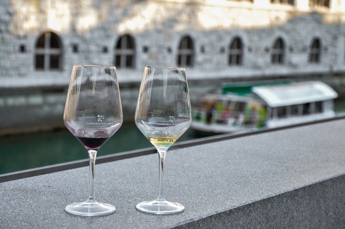 Enjoy two glasses of wine on a beautiful river ledge in Ljublana.