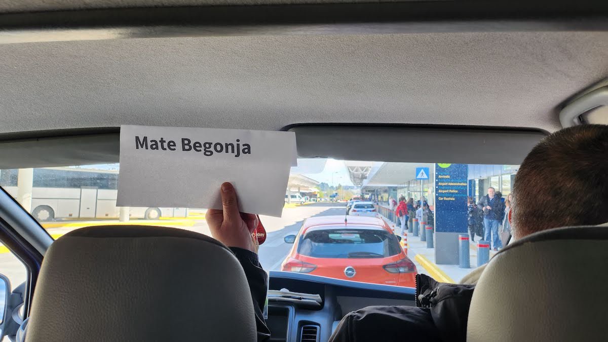 Mate Begonja holding up a sign in the back seat of a private transfer