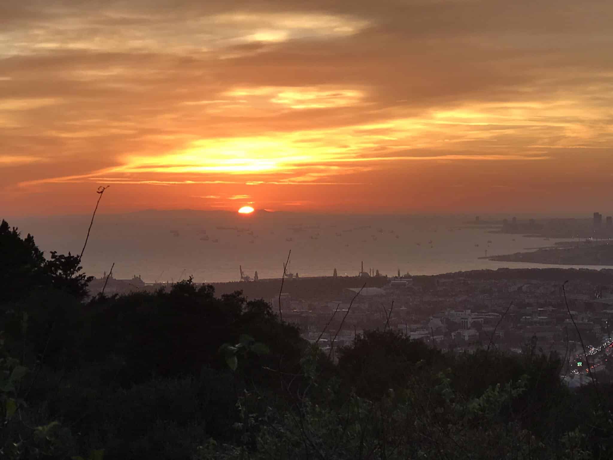 The sun is setting over the city of barcelona.