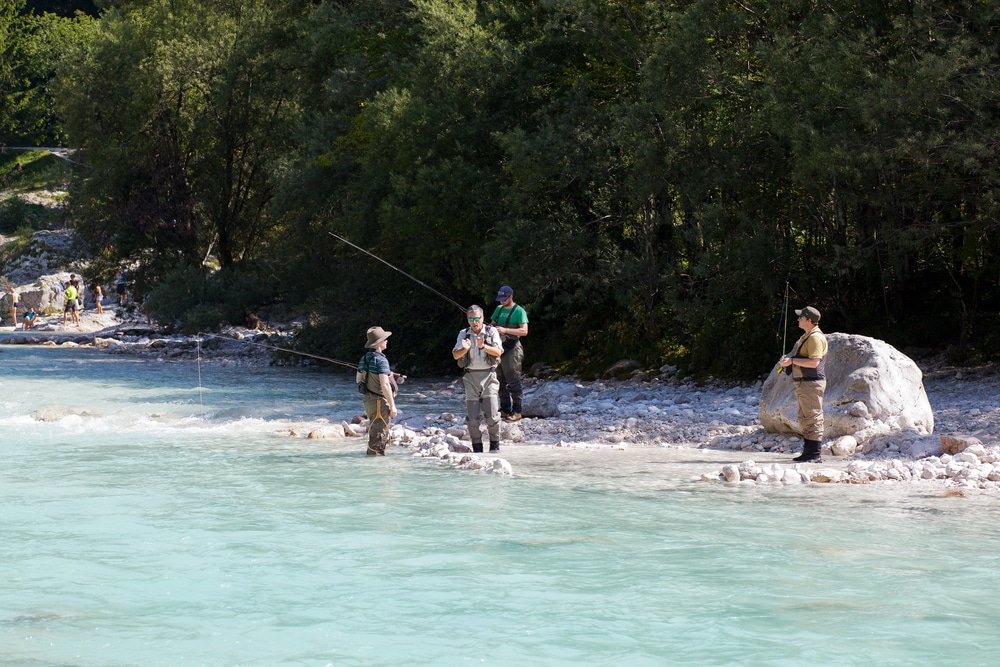 A group of people fishing in the Soča River Valley.