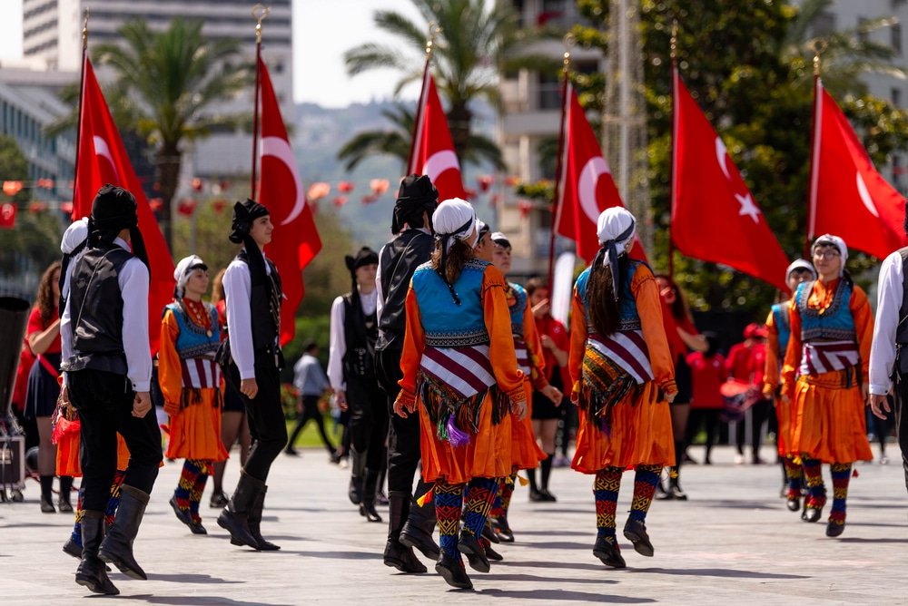 Turkish Horon dancers showcasing their traditional customs with flags in a vibrant plaza. Dancing the Hora
