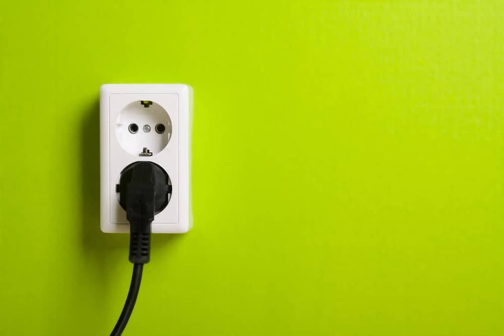 A white power plug on a green wall in Turkey