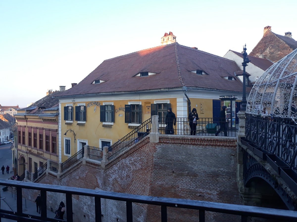 A yellow building with a black railing. Buildings in the Sibiu City center