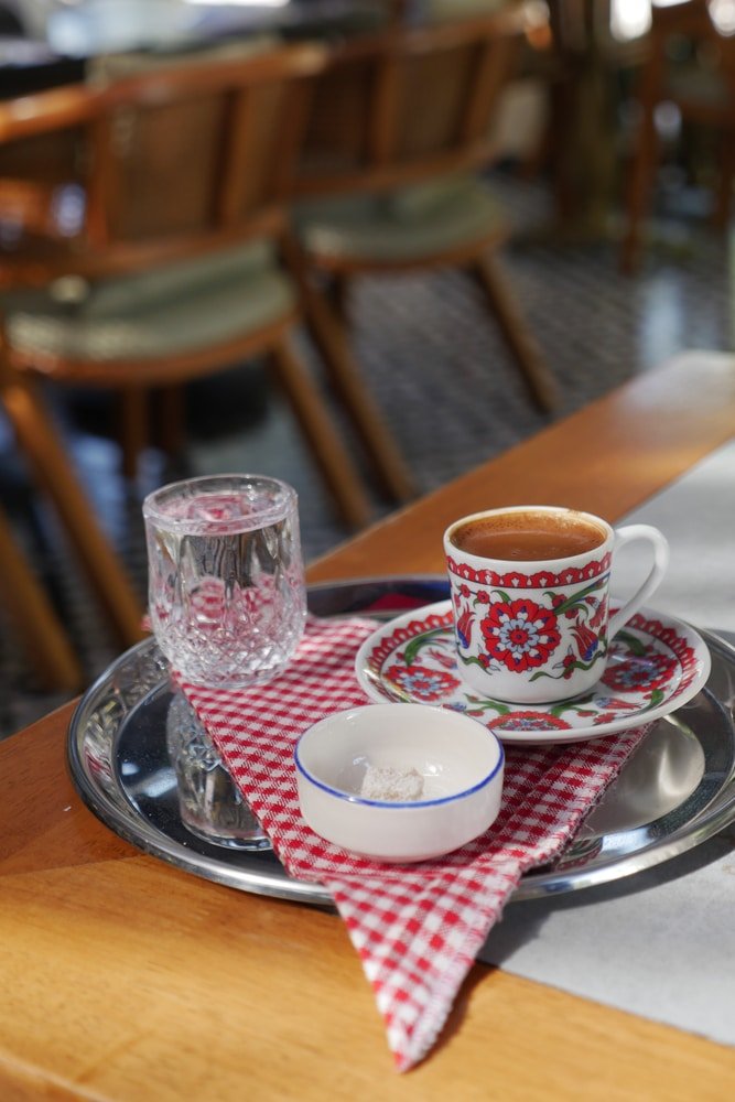 The best Turkish coffee in Istanbul, served on a tray with a cup of coffee and a glass of water.