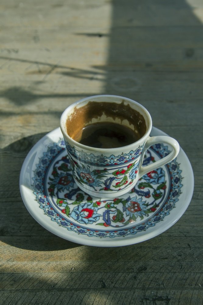 A cup of Turkish coffee on a saucer, with its rich aroma and traditional brewing process, embodies the essence of Turkish traditions and customs.