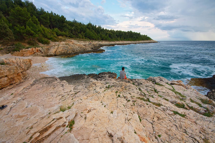 A person sitting on a rocky beach in Brač.