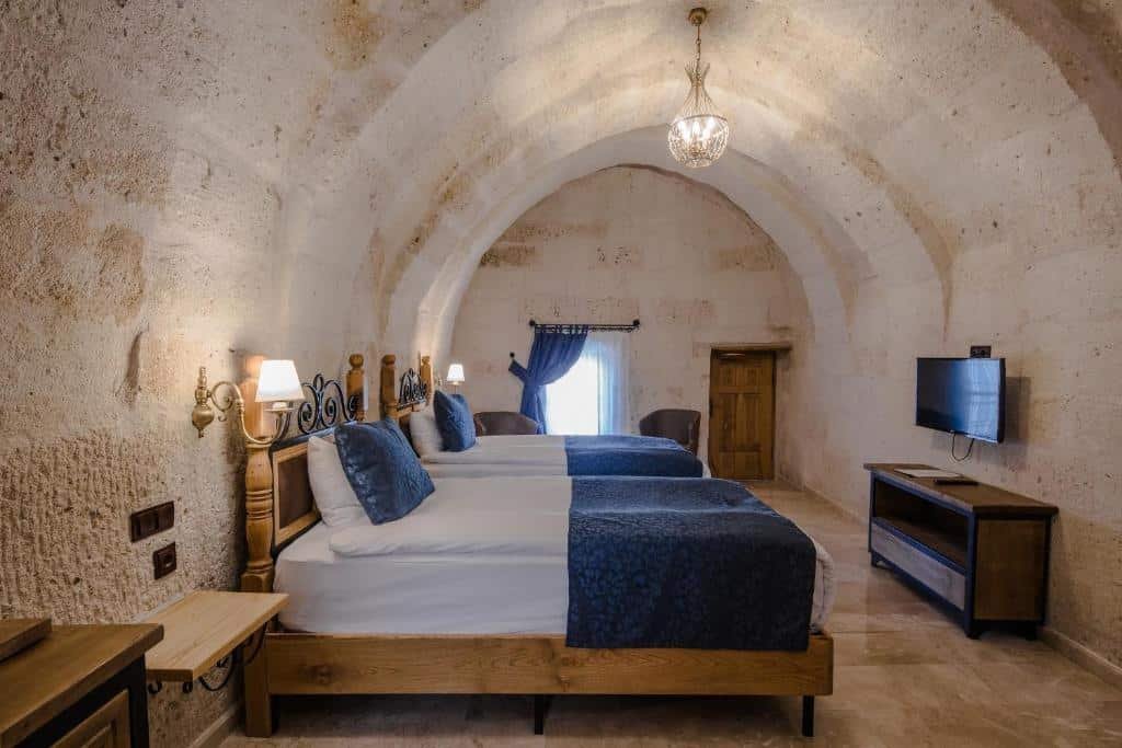 A luxury bed or beds in a room with an arched ceiling in Luna Cave Hotel in Cappadocia.