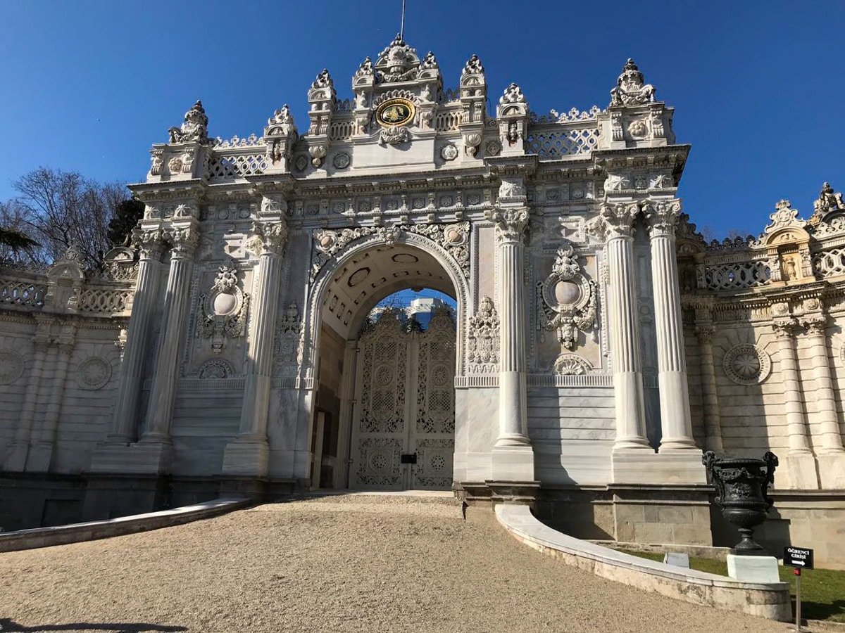 A large white stone gate with ornate carvings at Dolmabahçe Palace