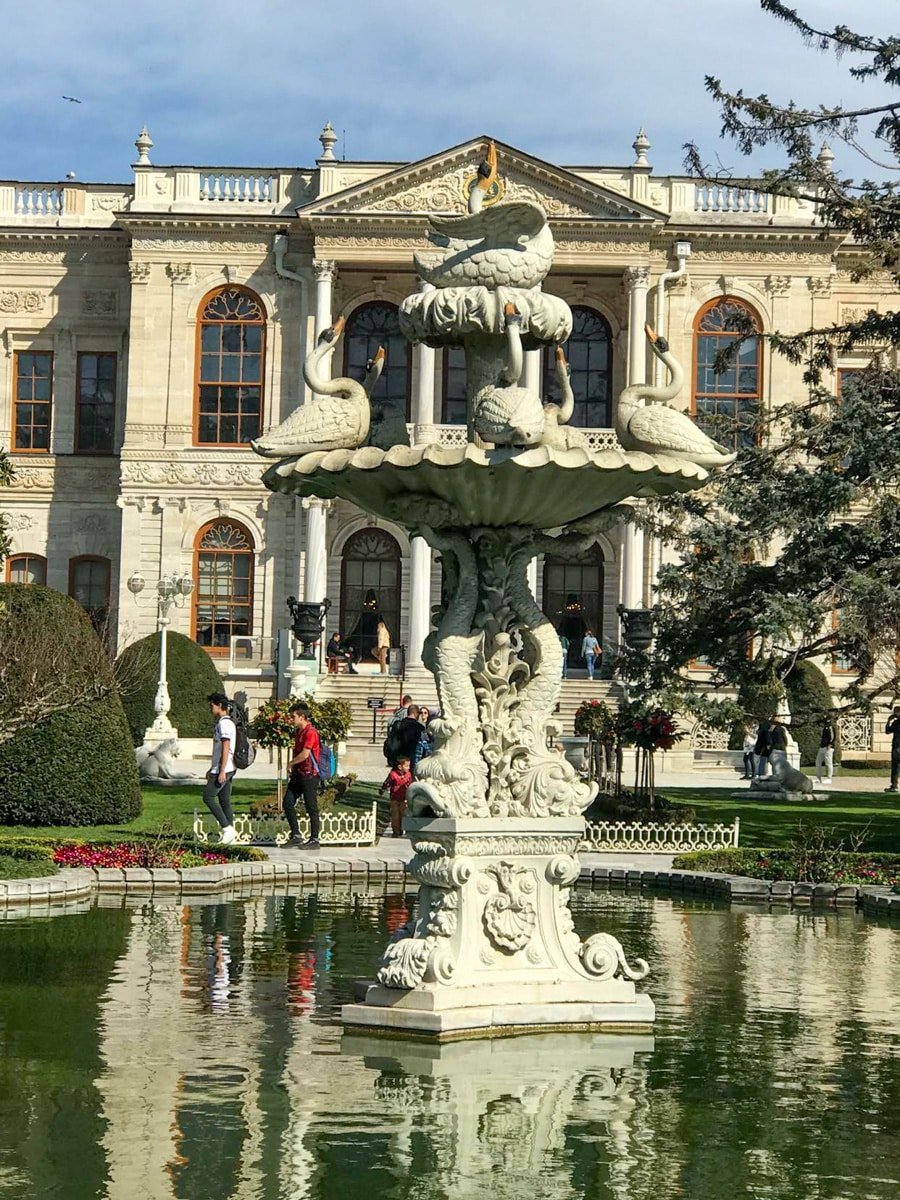 A fountain in front of a large mansion at Dolmabahce palace