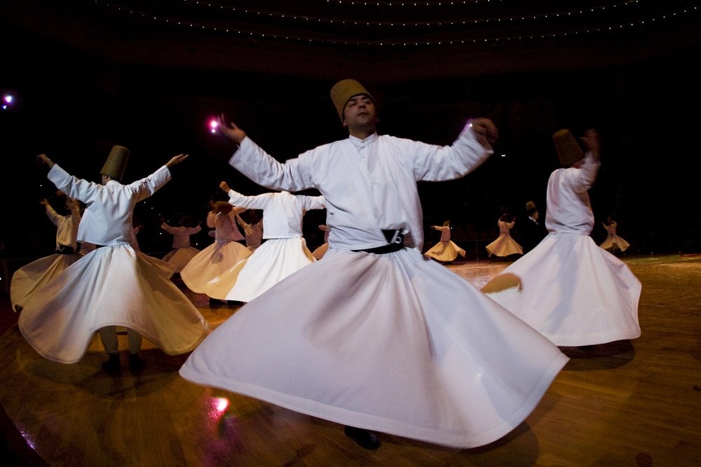 A group of men wearing white robes performing a traditional Mevlana dance at the festival in Konya.