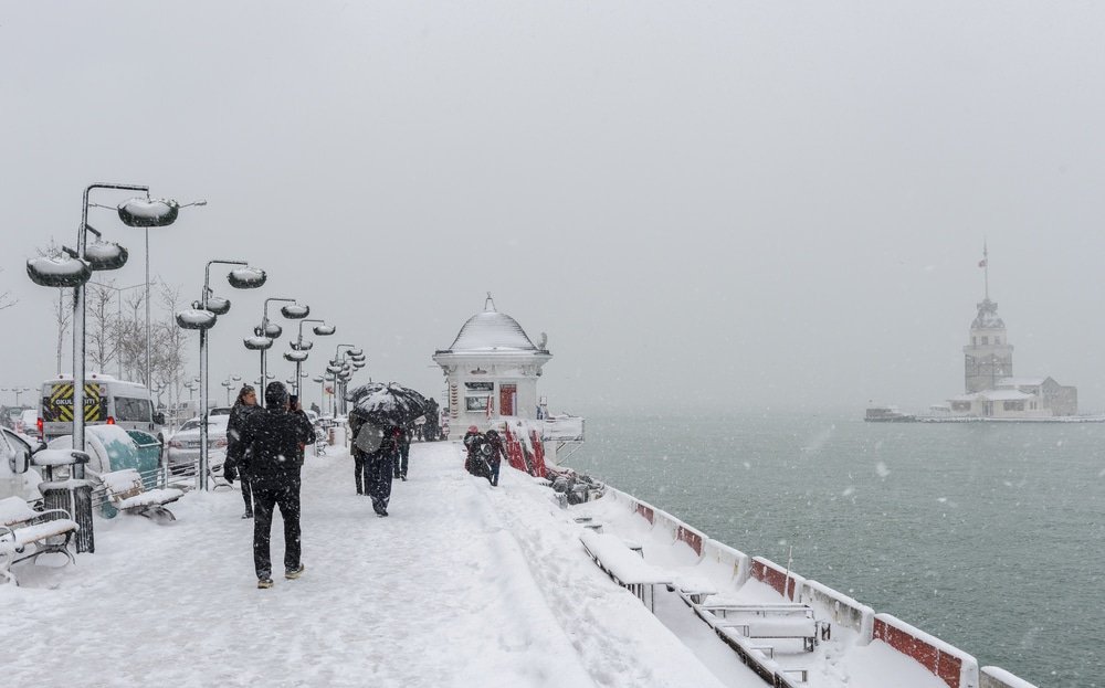 A group of people walking in Uskudar, Istanbul pier in the snow.