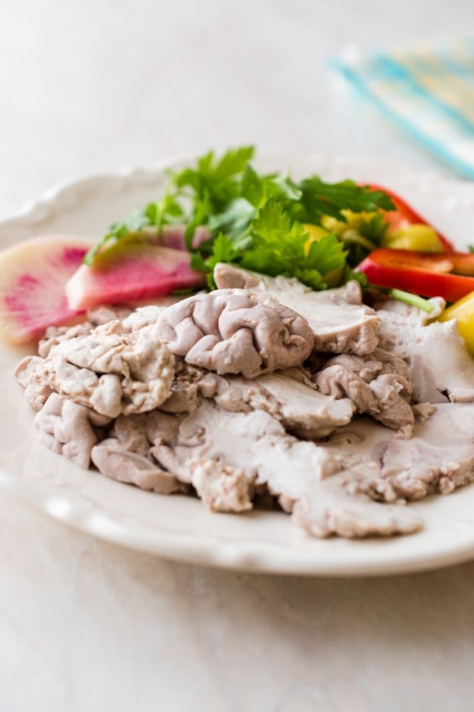 A plate of Turkish Offal Food Lamb Brain with Salad / Beyin Sogus served with with a side of fresh vegetables.
