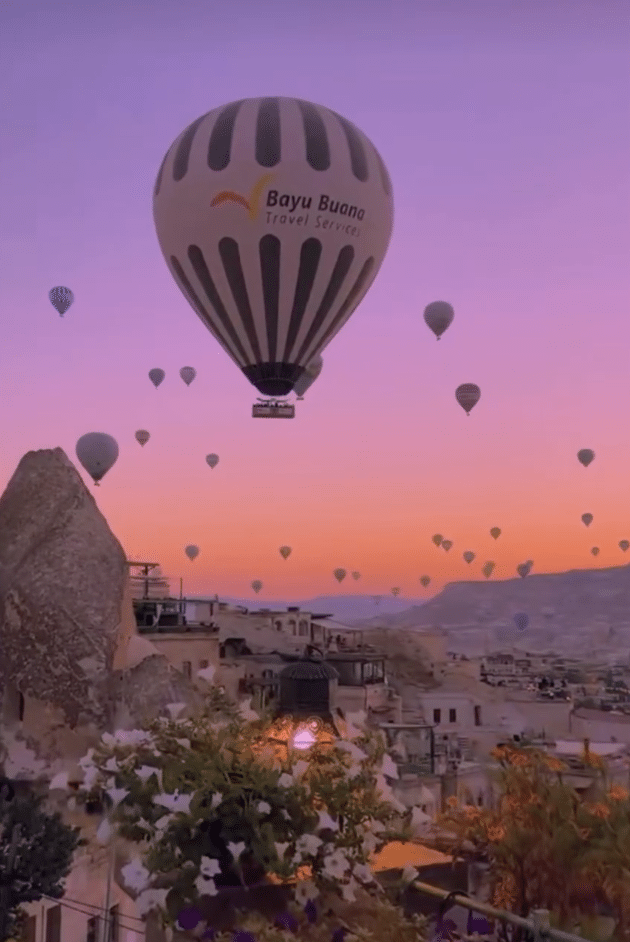 Hot air balloons flying over a natural attraction in Cappadocia, Turkey.