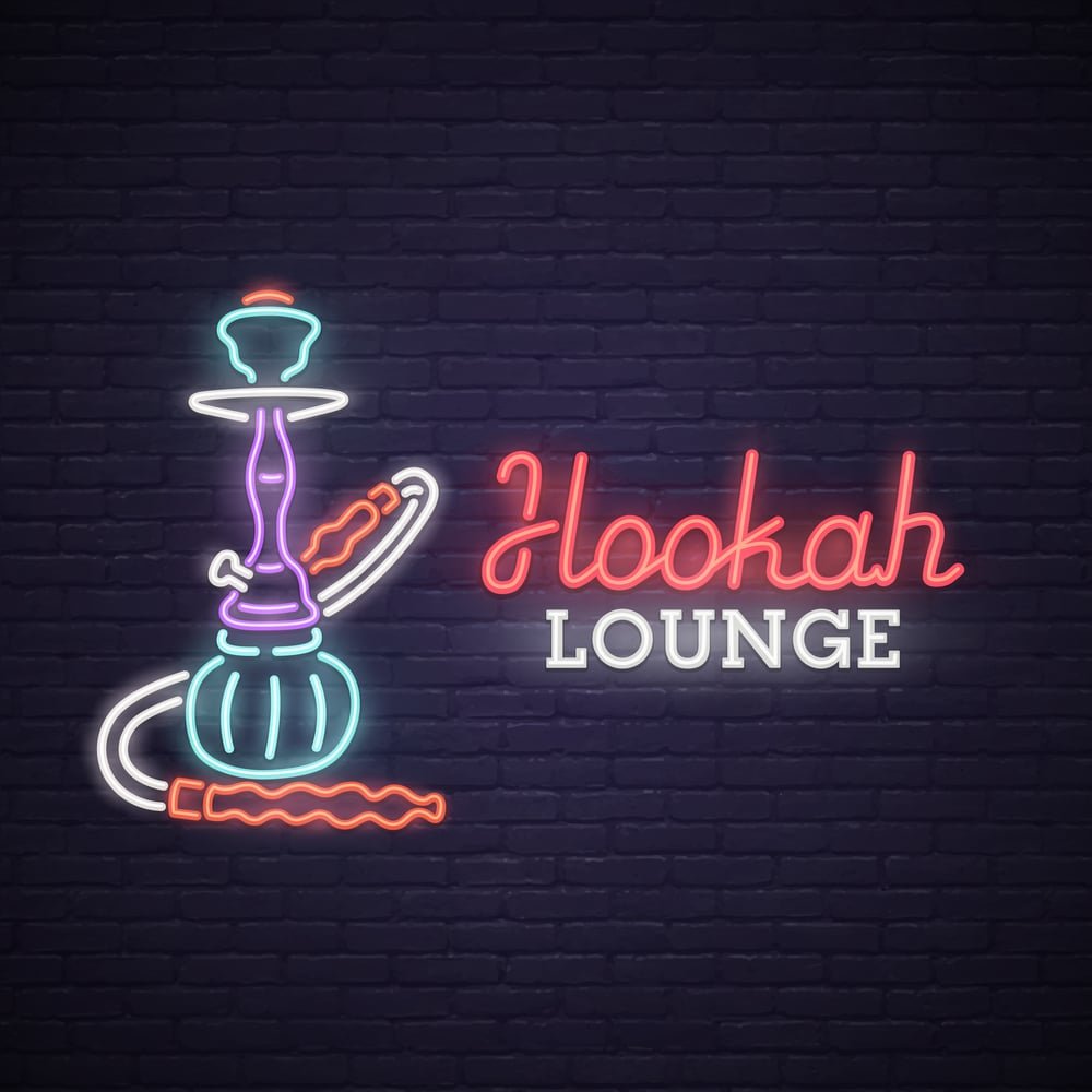 A neon hookah lounge sign on a brick wall in Istanbul.