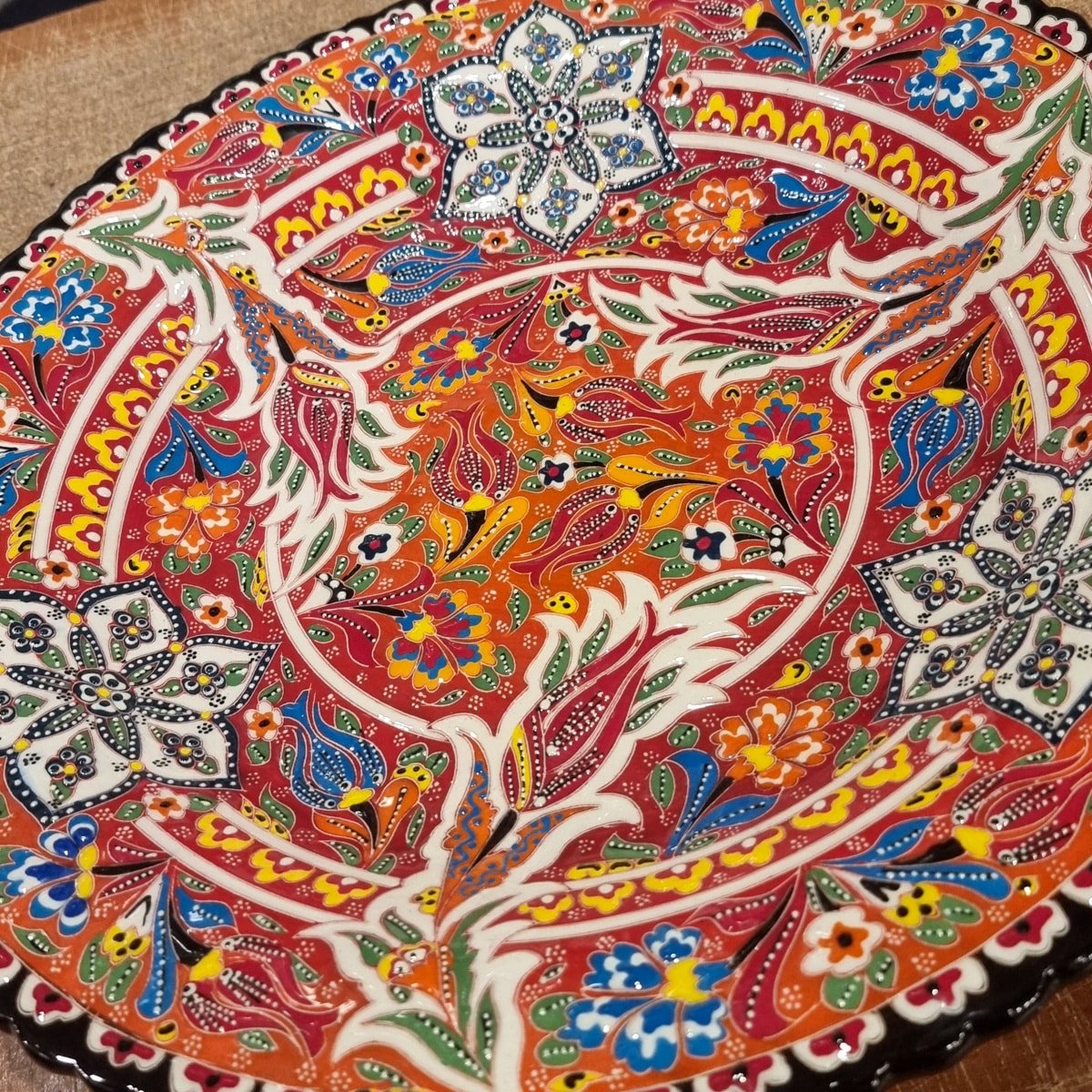Close-up of a colorful, intricately designed ceramic plate from Avanos, Cappadocia, featuring vibrant floral and geometric patterns.