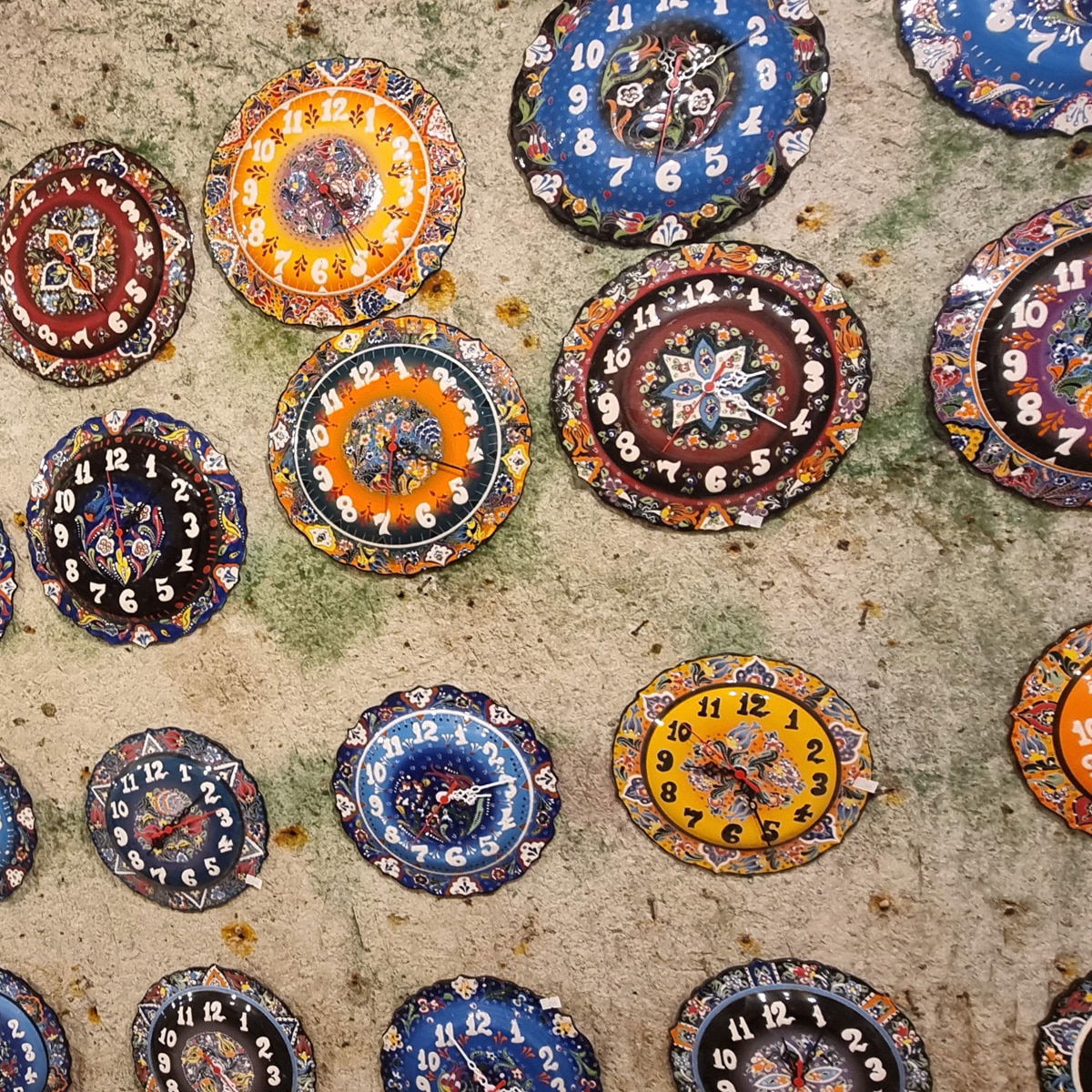 Decorative ceramic plates with intricate, colorful patterns and things to do in Avanos Cappadocia, Turkey mounted on a textured wall.