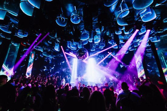 The Belgrade nightlife comes alive with vibrant purple and blue lights illuminating the energetic dance floor, where a disco ball spins above a lively crowd. This is one of the premier places to party in the city, offering an unforgettable night filled with music and excitement.