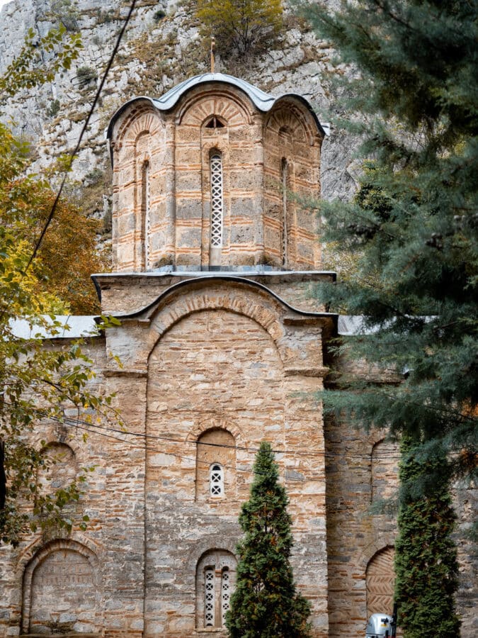 Nestled against a rocky hillside near Skopje, this ancient stone church boasts arched windows and a towering presence. Surrounded by lush trees, it's a must-see in any travel guide to the region, offering a serene escape not far from the stunning Matka Canyon.